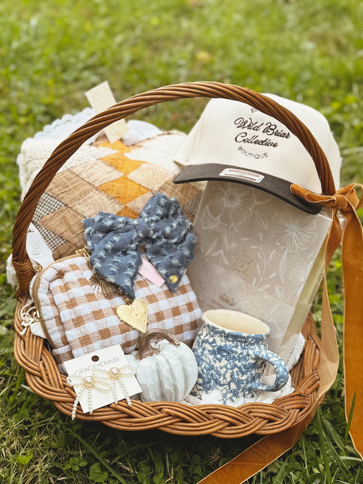 Woven gift basket with a baseball cap, blue mug, and handmade fabric accessories.