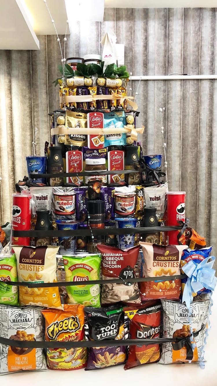 Pyramid tower of assorted snack bags and treats tied with gold ribbons.