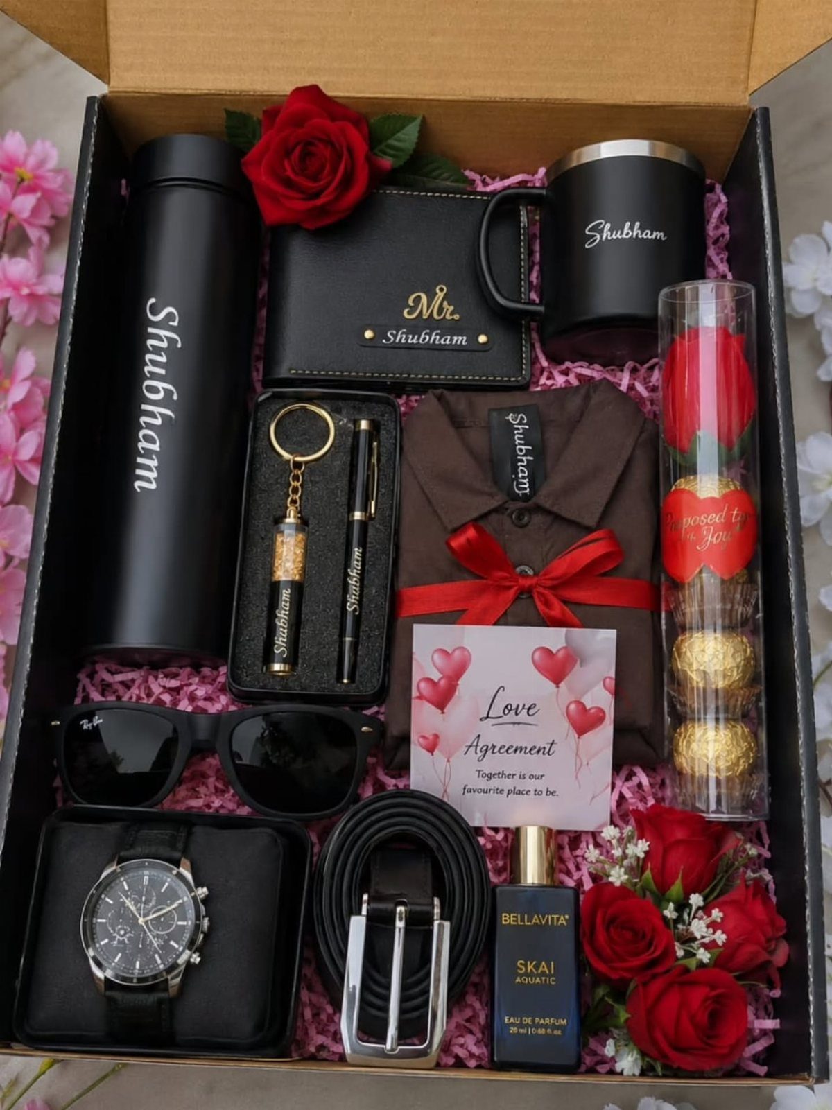 17 Anniversary Boyfriend Gifts He'll Actually Use (2026) 16 Personalized gift box for men containing a watch, wallet, mug, and red roses.