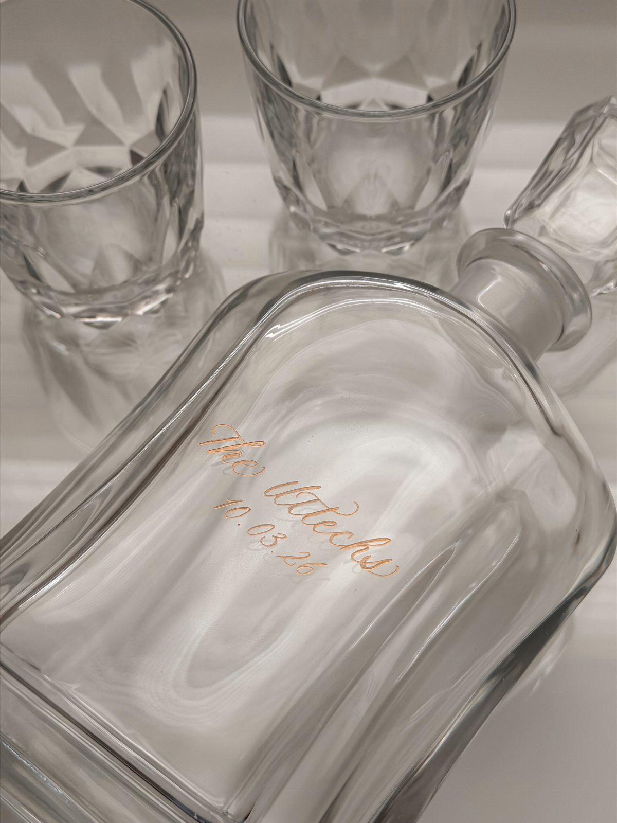 17 Anniversary Boyfriend Gifts He'll Actually Use (2026) 1 Engraved glass decanter and two crystal whiskey glasses on a white background