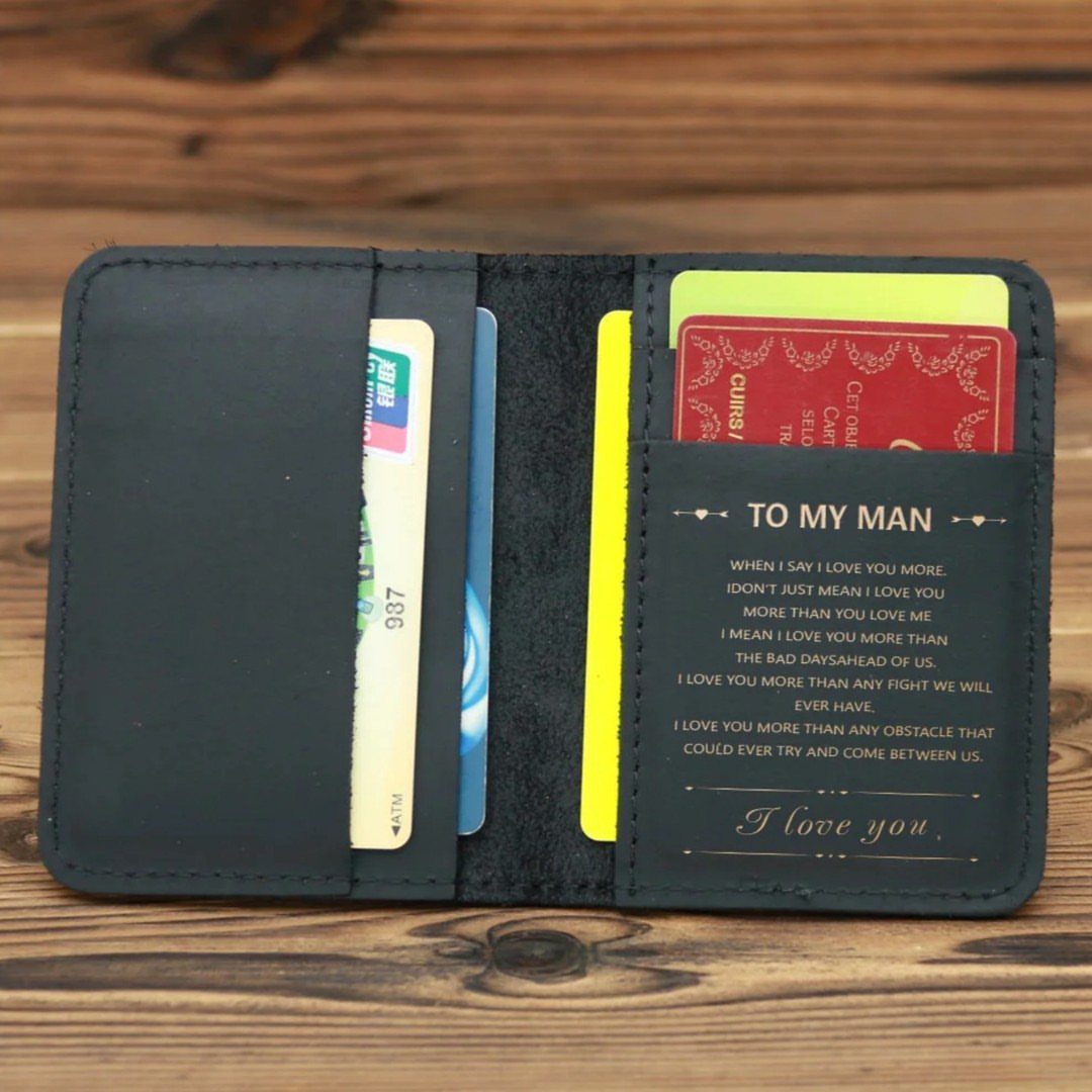 17 Anniversary Boyfriend Gifts He'll Actually Use (2026) 3 Black leather wallet with engraved romantic message and credit cards on wooden background