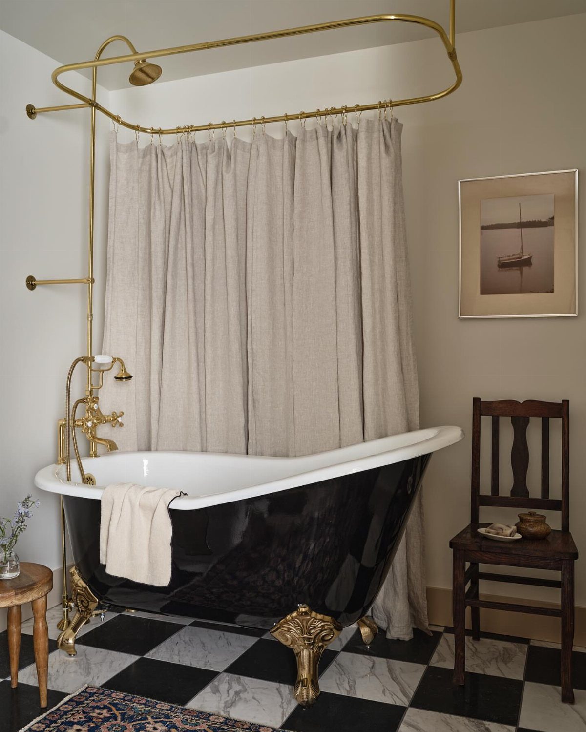 8 Bathroom Gift Ideas for Spa Nights and Everyday Use 6 Black clawfoot bathtub with gold accents on a checkered bathroom floor