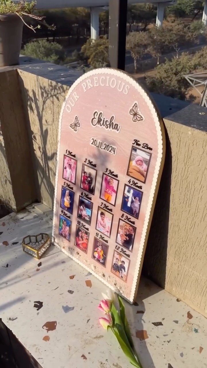 Arched wooden photo collage board with baby photos and personalized name and date.