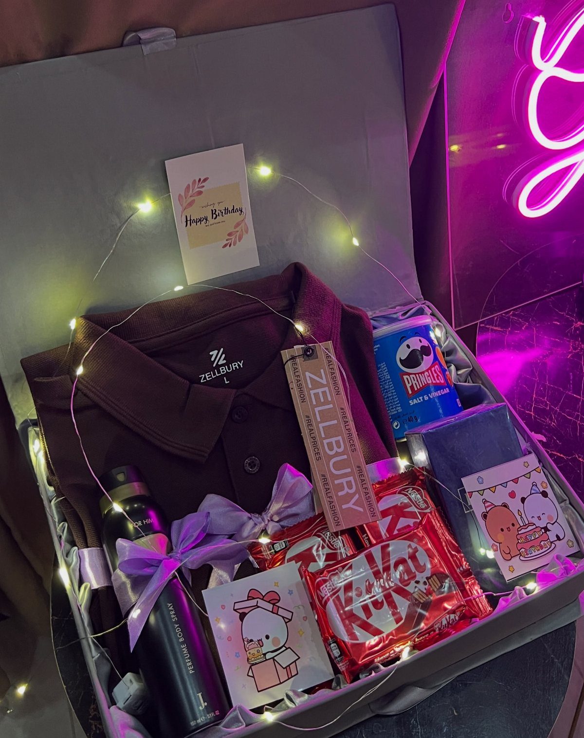 13 Ideas for a Birthday Gift for a Man Who Has Everything 13 Gift box with brown polo shirt, snacks, and water bottle for a birthday.