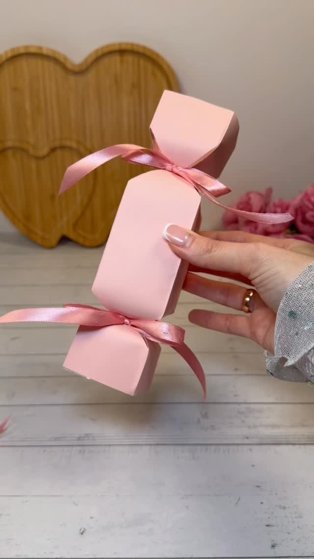 Birthday Gift Wrapping Ideas: 9 Ways to Wrap a Present 7 Pink candy-shaped gift box tied with satin ribbons held by a hand