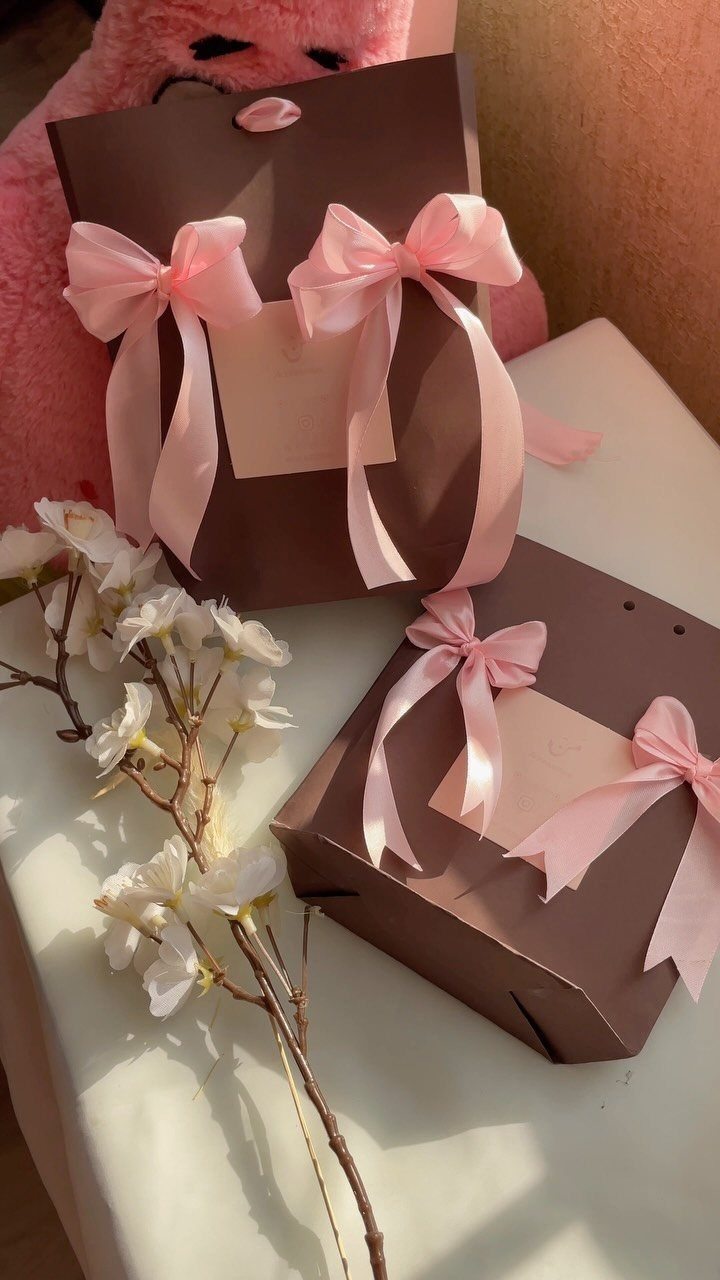 Birthday Gift Wrapping Ideas: 9 Ways to Wrap a Present 6 Brown gift boxes tied with pink satin bows next to white blossoms