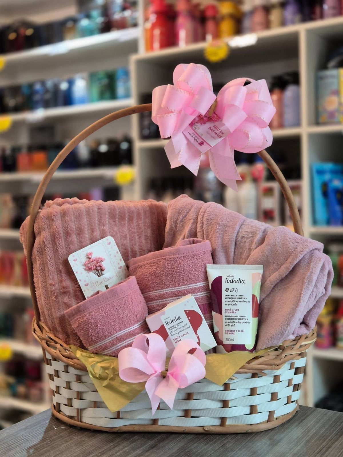 11 Bridal Shower Gift Basket Ideas for Every Bride-to-Be 10 Wicker gift basket filled with pink towels, soaps, and lotion with pink bows.