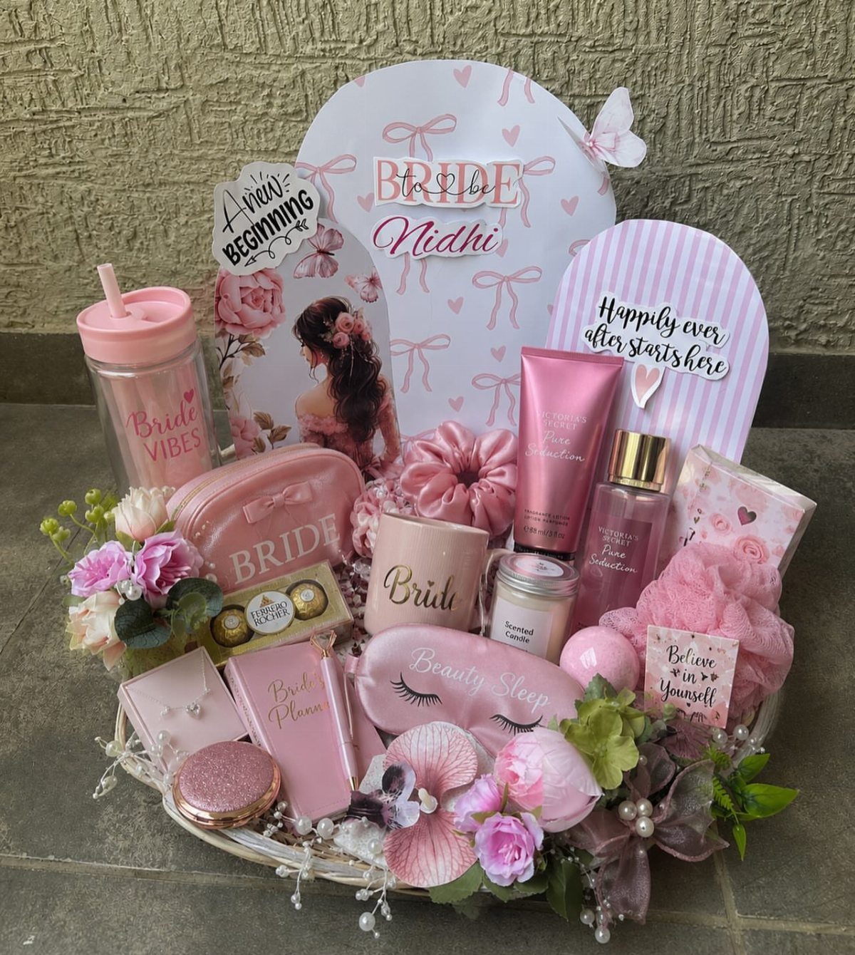 11 Bridal Shower Gift Basket Ideas for Every Bride-to-Be 1 Pink bridal self-care gift basket with skincare, sleep mask, and floral decorations.