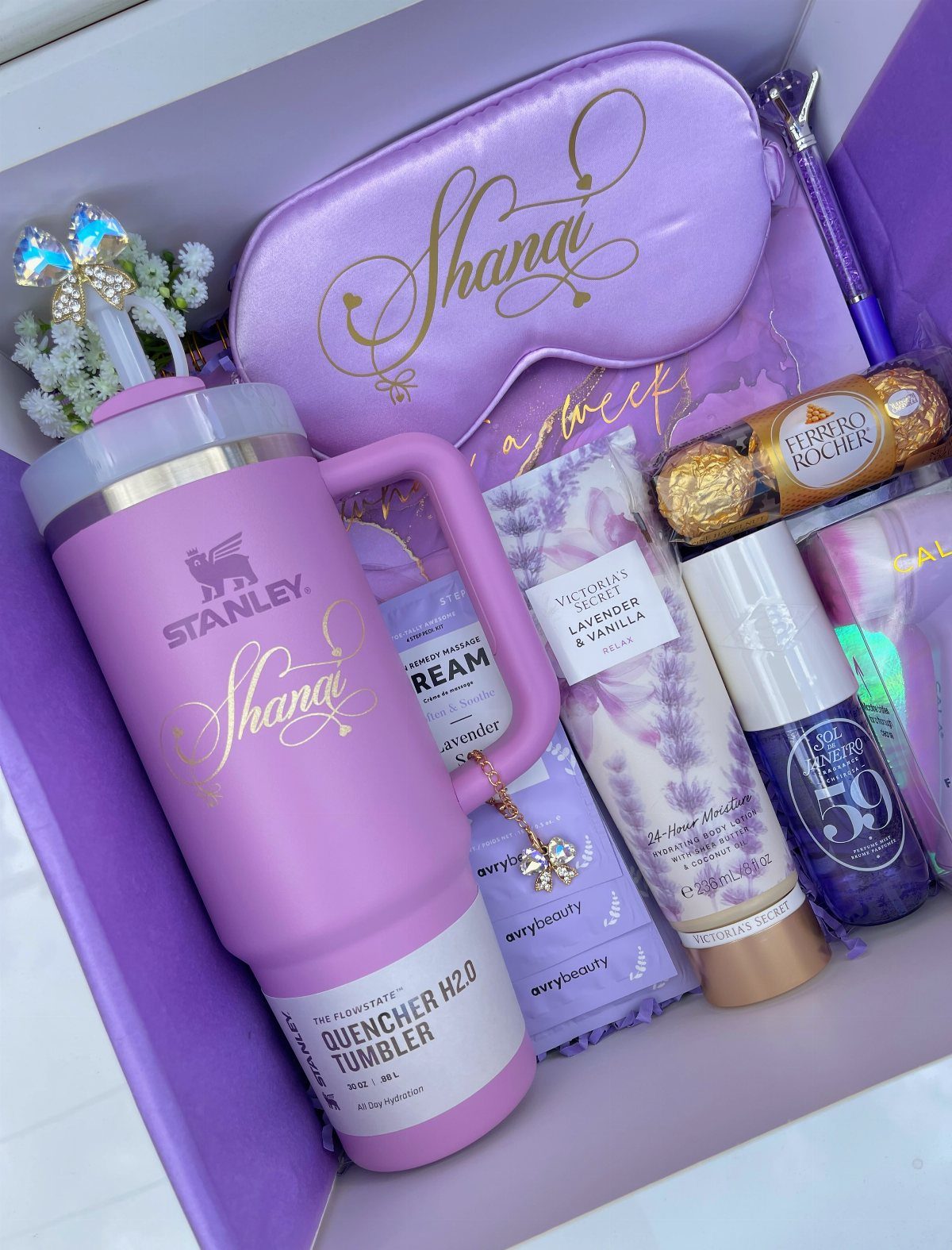 Purple gift box filled with a Stanley tumbler, sleep mask, and beauty products.