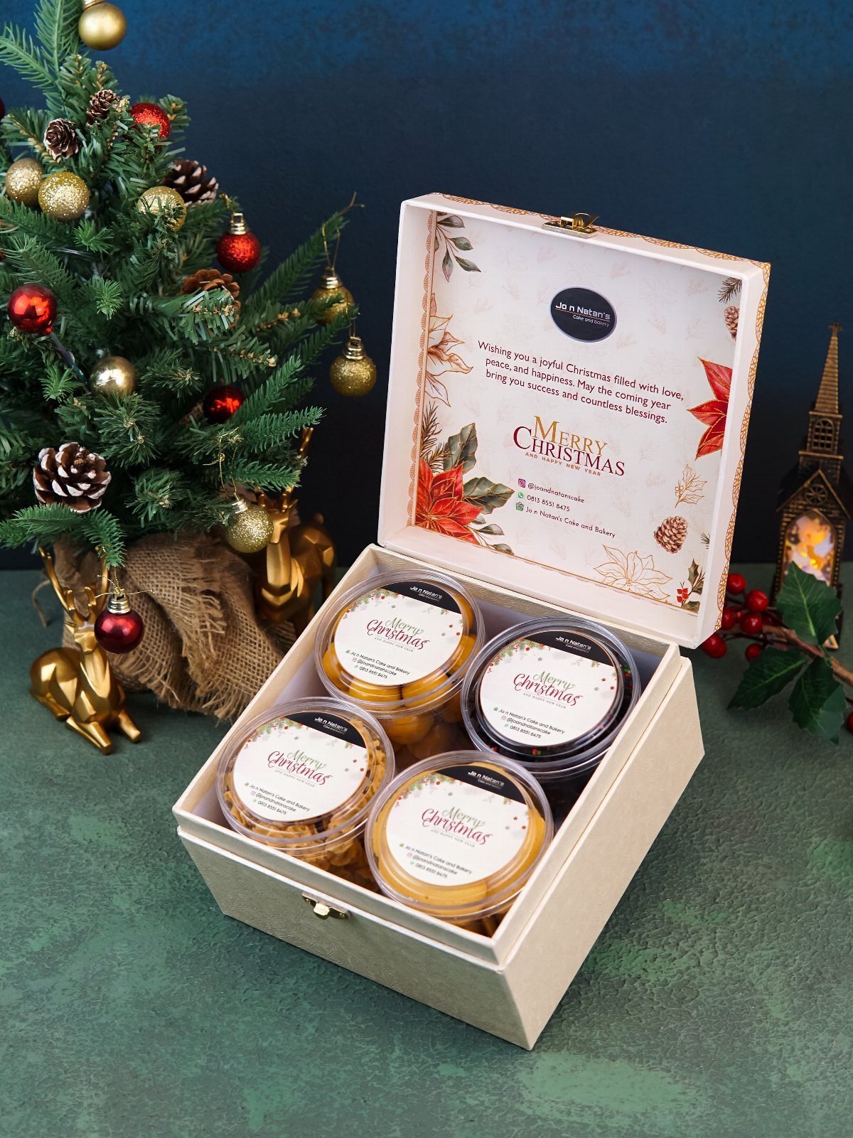 Christmas Food Basket Gift Ideas: 10 Options to Give 5 White gift box with four tubs of cookies next to a decorated Christmas tree.
