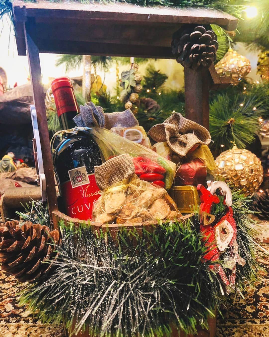 Christmas Food Basket Gift Ideas: 10 Options to Give 6 Wine gift basket with red wine, snack bags, and festive Christmas decorations.