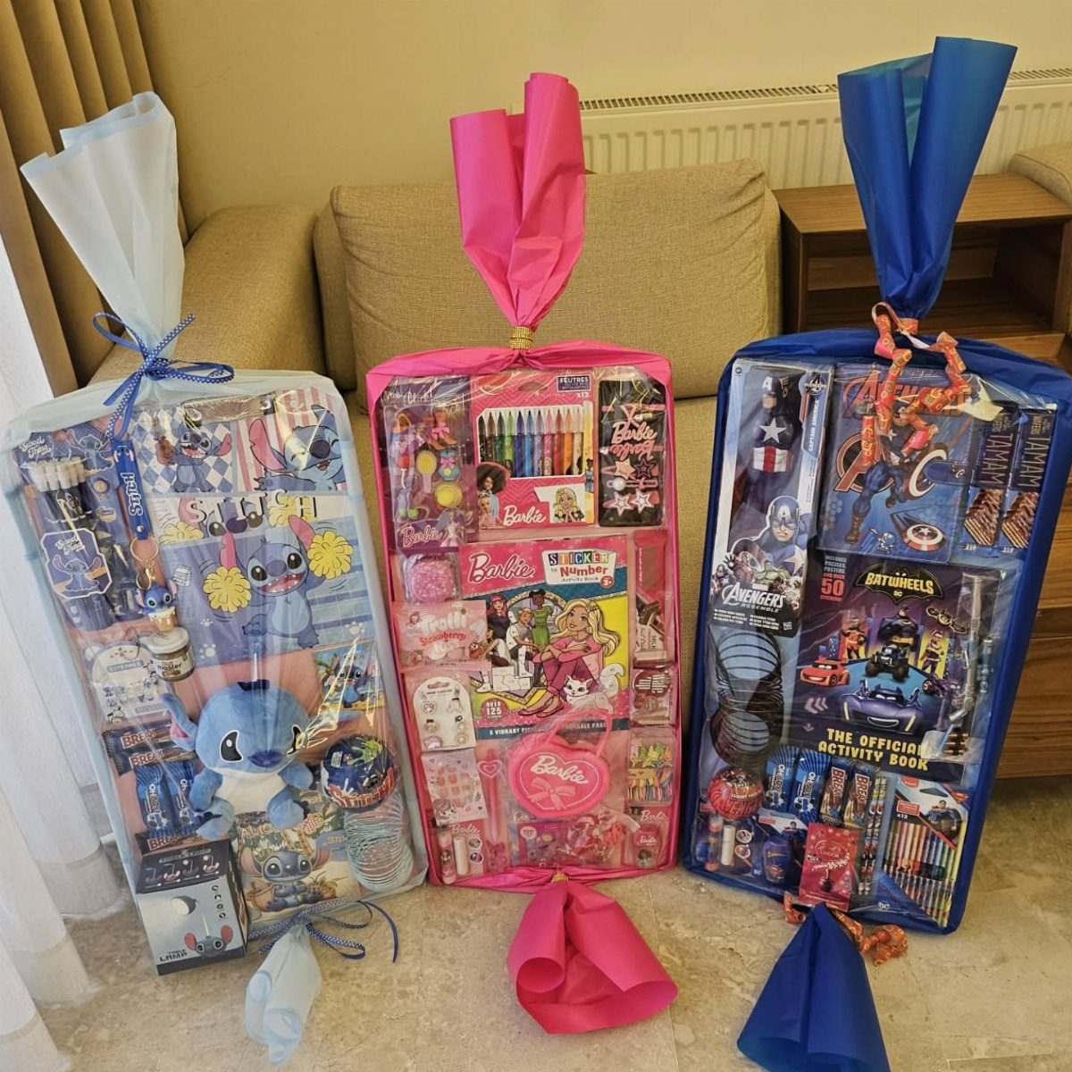 Christmas Gift Baskets for Family: 7 Ideas for Every Age 6 Three themed gift baskets with Pokemon, Barbie, and Avengers toys and activities.