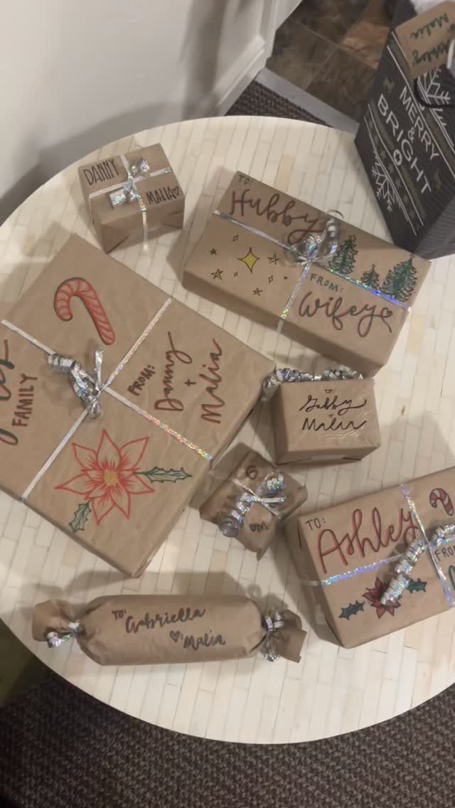 Christmas Gift Wrapping: 5 Ideas for Paper, Bows and Bags 4 Brown craft paper wrapped gifts with festive drawings and silver ribbons on a table