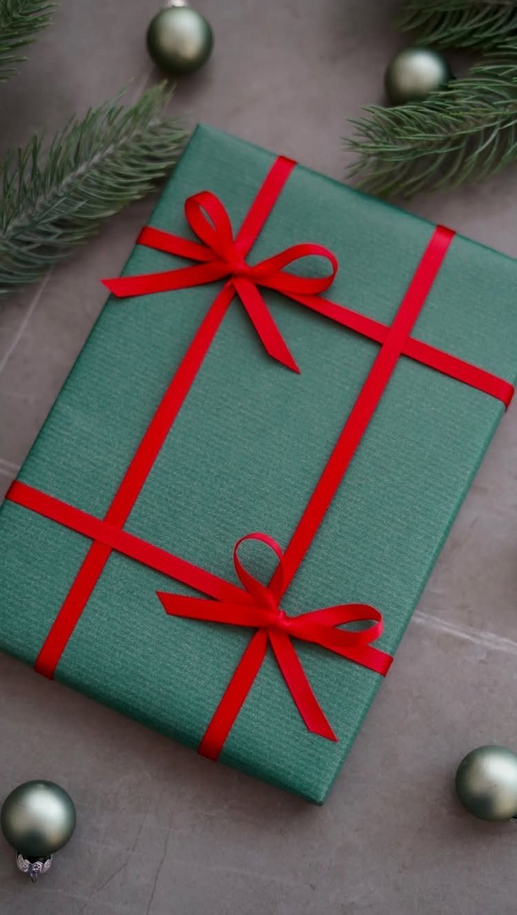 Christmas Gift Wrapping: 5 Ideas for Paper, Bows and Bags 2 Green wrapped gift with two red ribbons and bows among pine branches