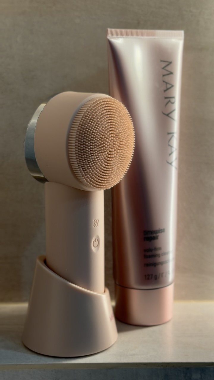 11 Christmas Gifts for Adults, From Waffle Makers to Desks 9 Beige facial cleansing brush and rose-gold skincare tube on a neutral surface.