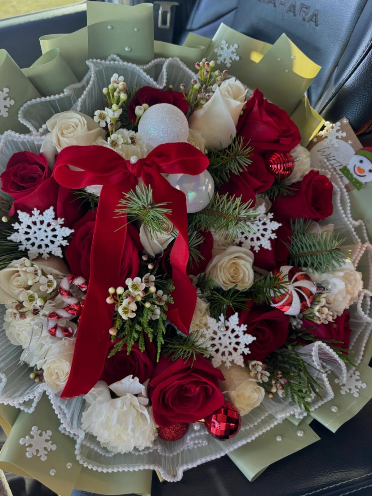 11 Christmas Gifts for Adults, From Waffle Makers to Desks 10 Festive bouquet of red and white roses with pine and Christmas ornaments.