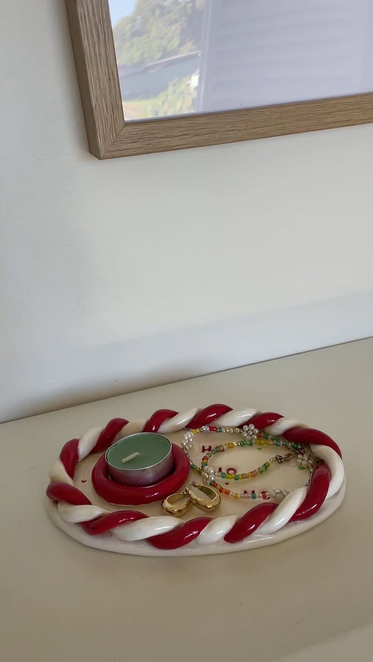 25 Christmas Gifts to Make at Home: Candles to Cookies 23 Candy cane themed jewelry tray holding a candle, beaded bracelet, and gold earrings.