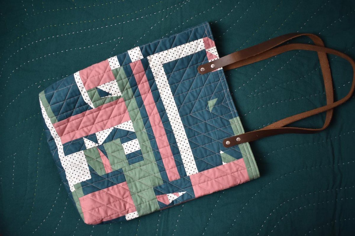 25 Christmas Gifts to Make at Home: Candles to Cookies 8 Quilted tote bag with geometric pink and green patterns and brown leather handles.