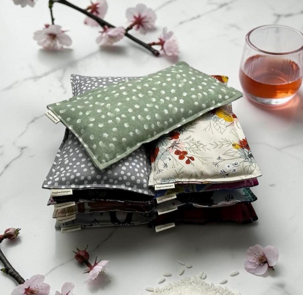 25 Christmas Gifts to Make at Home: Candles to Cookies 10 Stacked fabric heating pads in various patterns on a marble surface with blossoms.