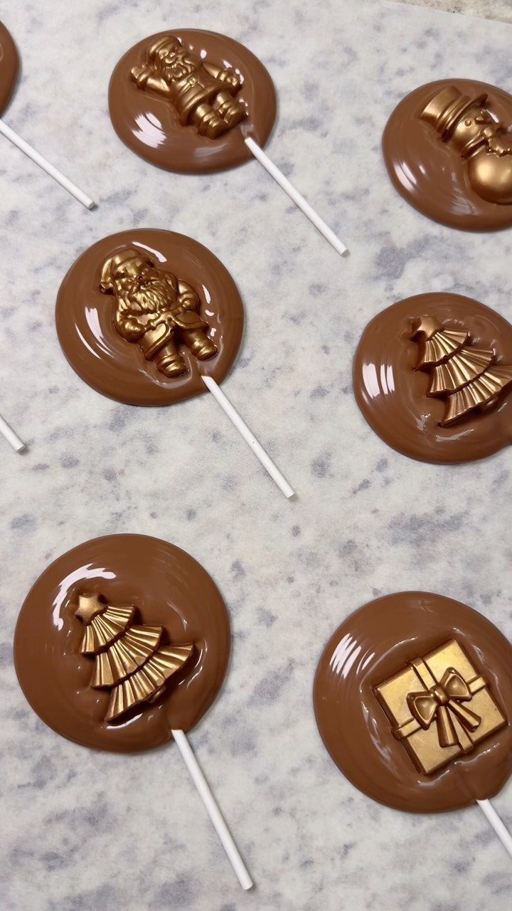 Christmas Stocking Gifts: 8 Small Ideas, Socks to Puzzles 1 Chocolate lollipops with gold Christmas decorations on a light grey marbled surface.