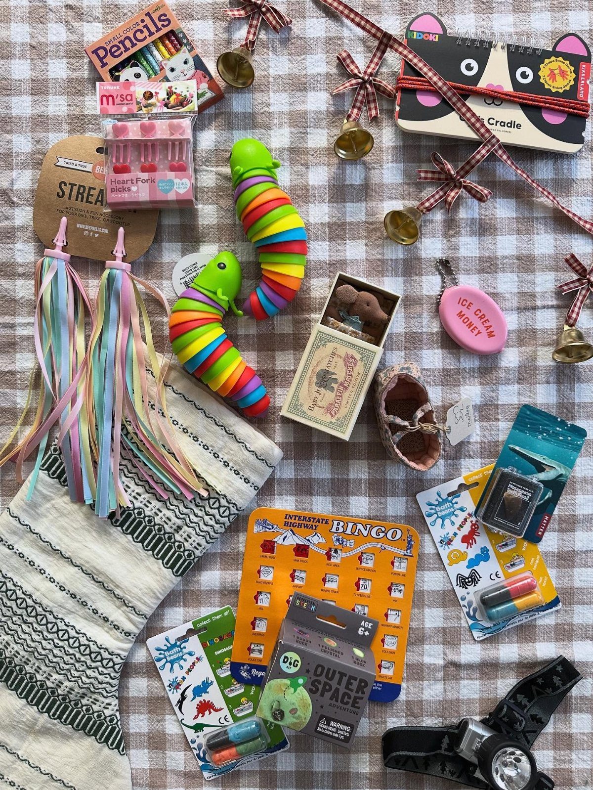 Christmas Stocking Gifts: 8 Small Ideas, Socks to Puzzles 2 Assorted small novelty gifts and a stocking arranged on a checkered fabric background.