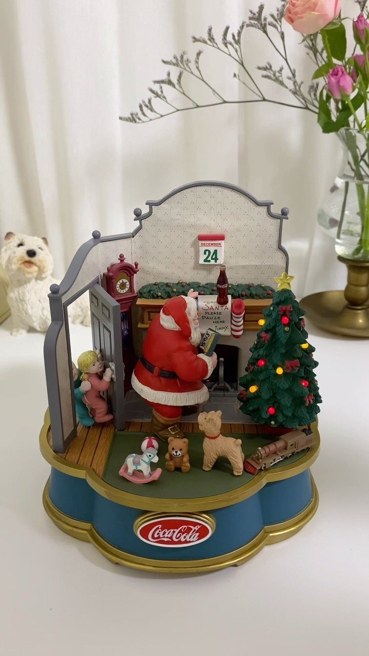 Coca-Cola Christmas Gift Ideas: 7 Picks for Fans 6 Coca-Cola Christmas figurine showing Santa Claus and a child by a decorated tree