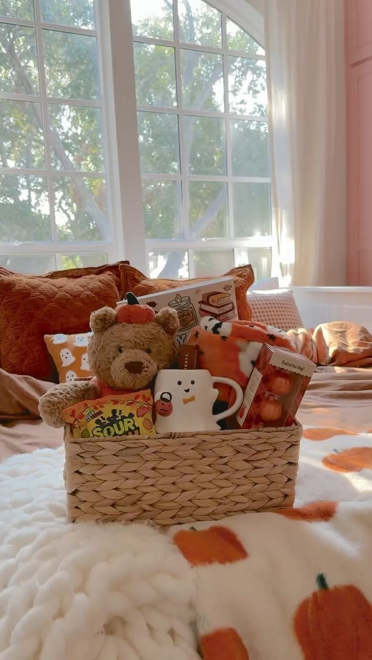 10 Cozy Gift Basket Ideas, from Spa Sets to Pumpkin Spice 3 Woven gift basket with teddy bear, book, and mug on a pumpkin blanket.