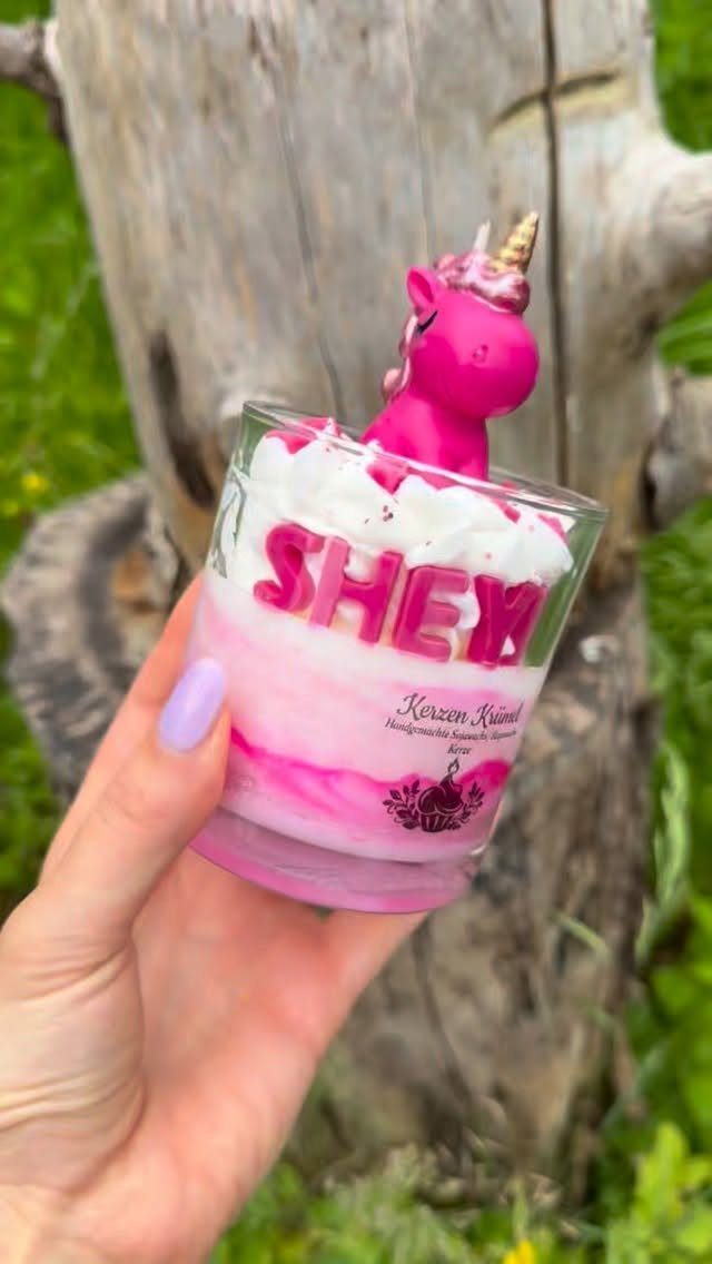 10 Cozy Gift Basket Ideas, from Spa Sets to Pumpkin Spice 6 Personalized pink unicorn candle in a glass jar held by a hand.
