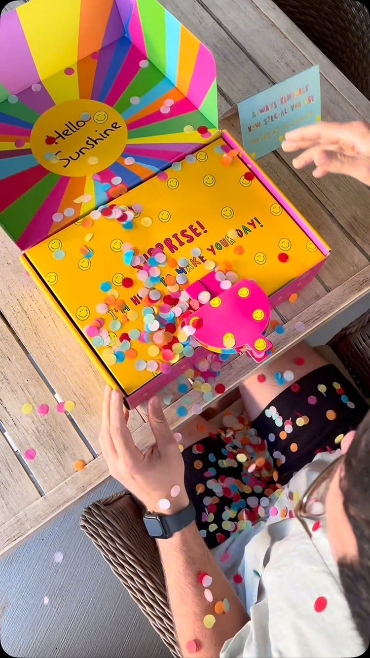 17 Creative Birthday Gifts for Friends and Family 13 Yellow surprise gift box with colorful confetti spilling out onto a wooden table