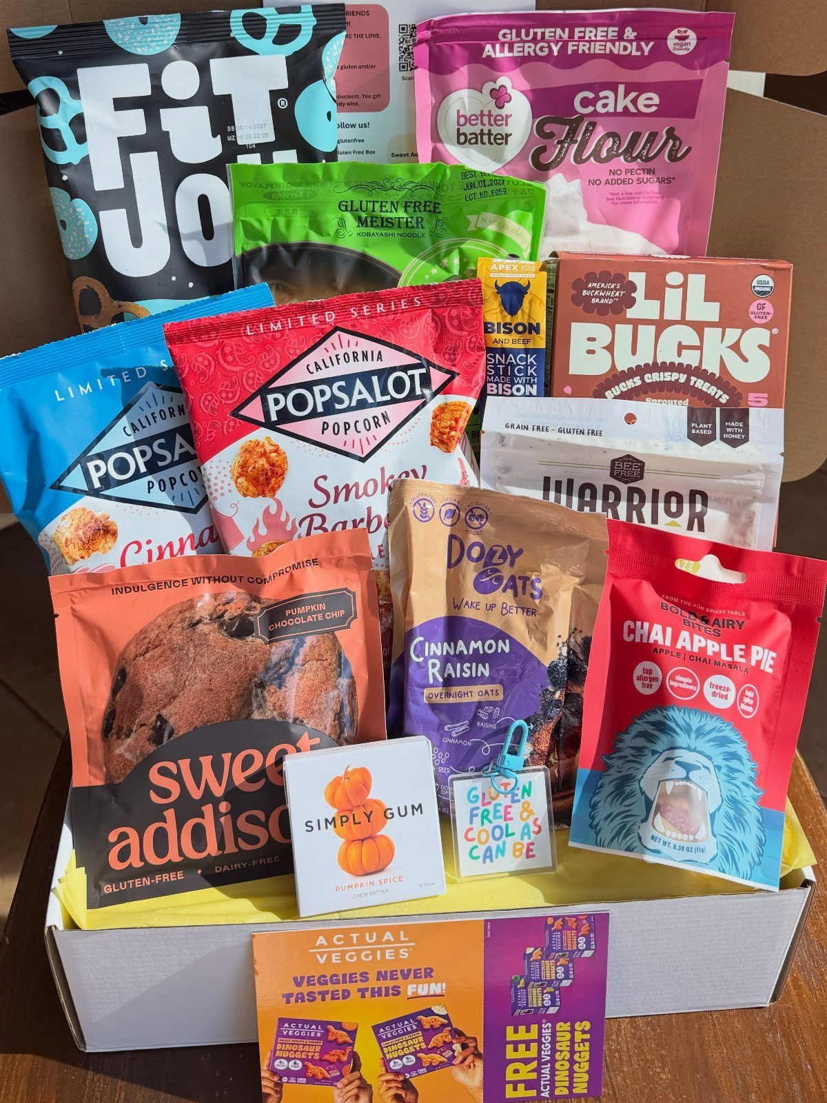 17 Creative Birthday Gifts for Friends and Family 7 Assorted packaged snacks and treats arranged inside a white cardboard gift box.