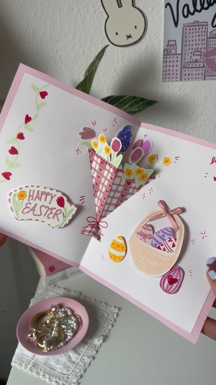 Pop-up Easter card with 3D flowers and a basket of colorful eggs.