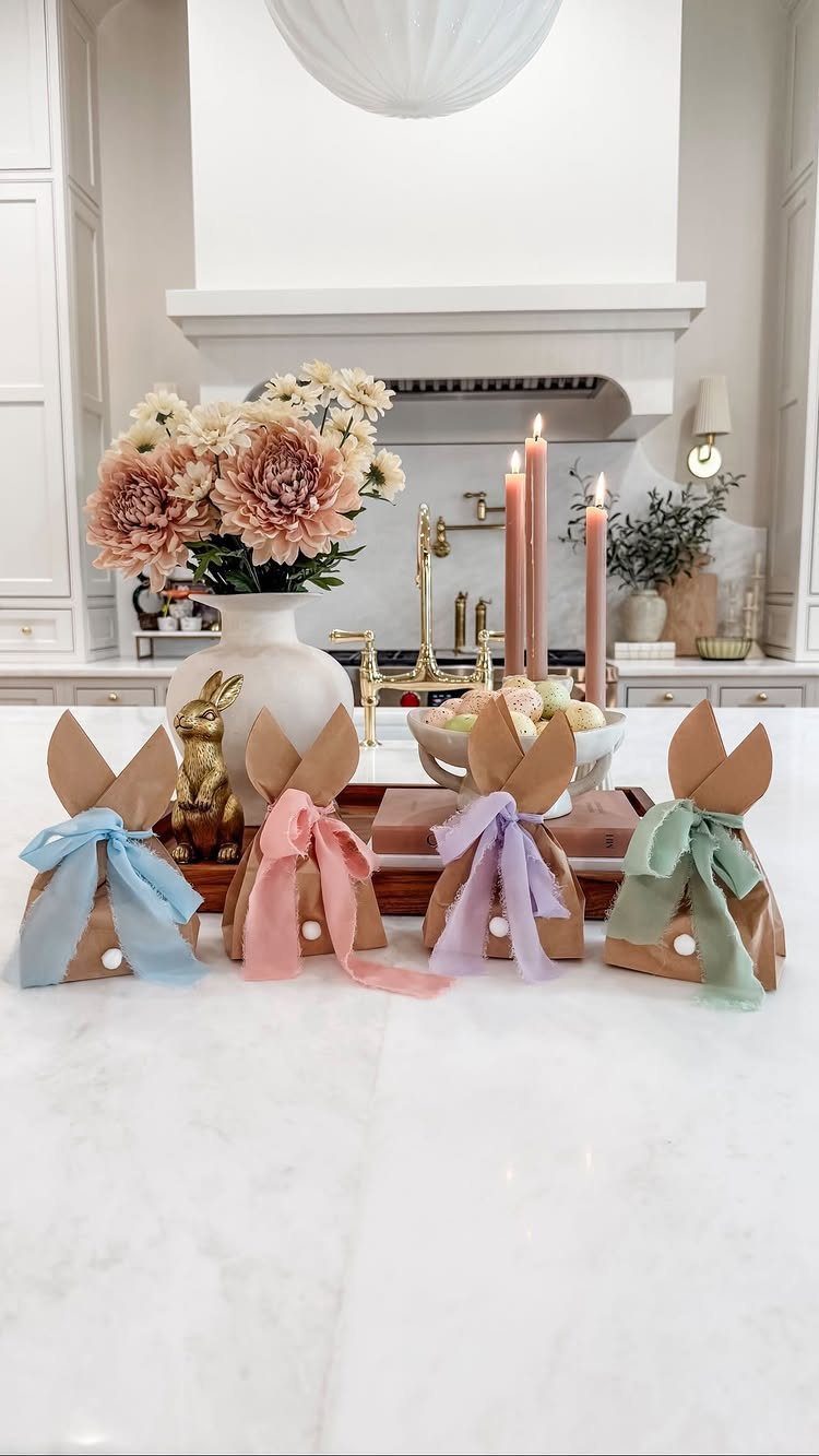 10 Easter Gifts for Young Adults They'll Actually Use 3 Bunny shaped brown paper gift bags with colorful ribbons on a marble counter.