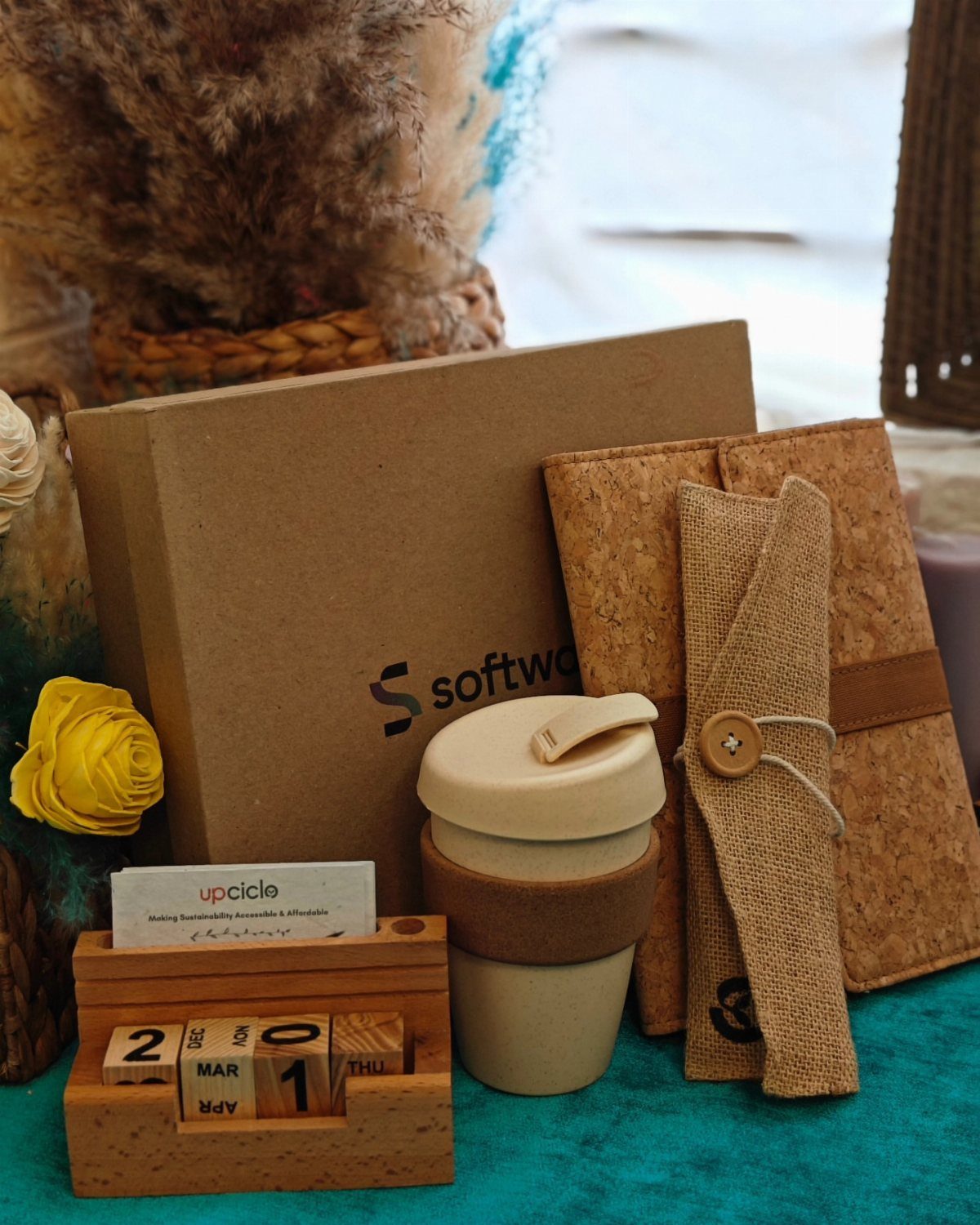 Sustainable office gift set with cork notebook, reusable cup, and wooden calendar.