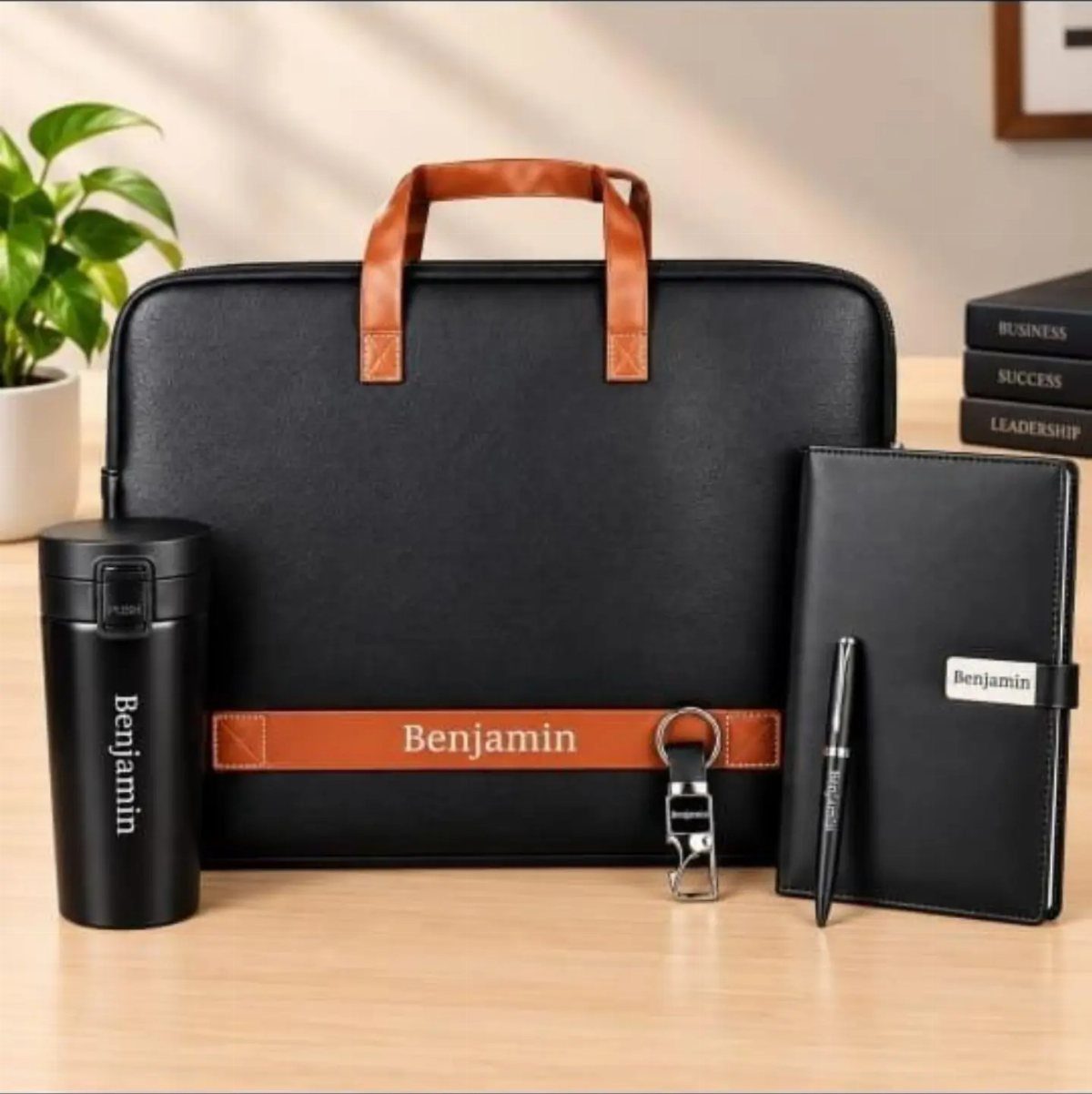 Personalized black corporate gift set including laptop bag, travel mug, notebook, and pen.