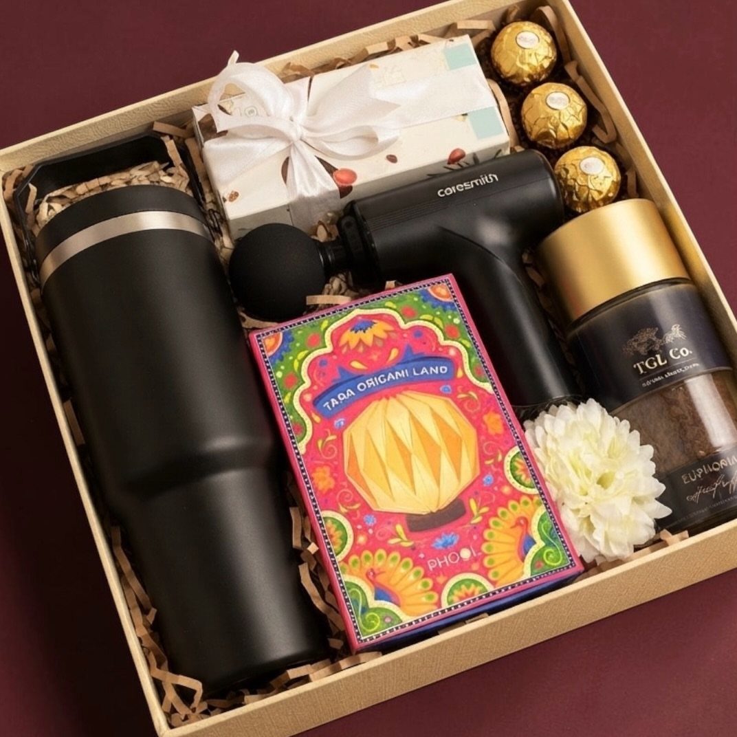 Wellness gift box containing a massage gun, travel mug, tea, and chocolates.