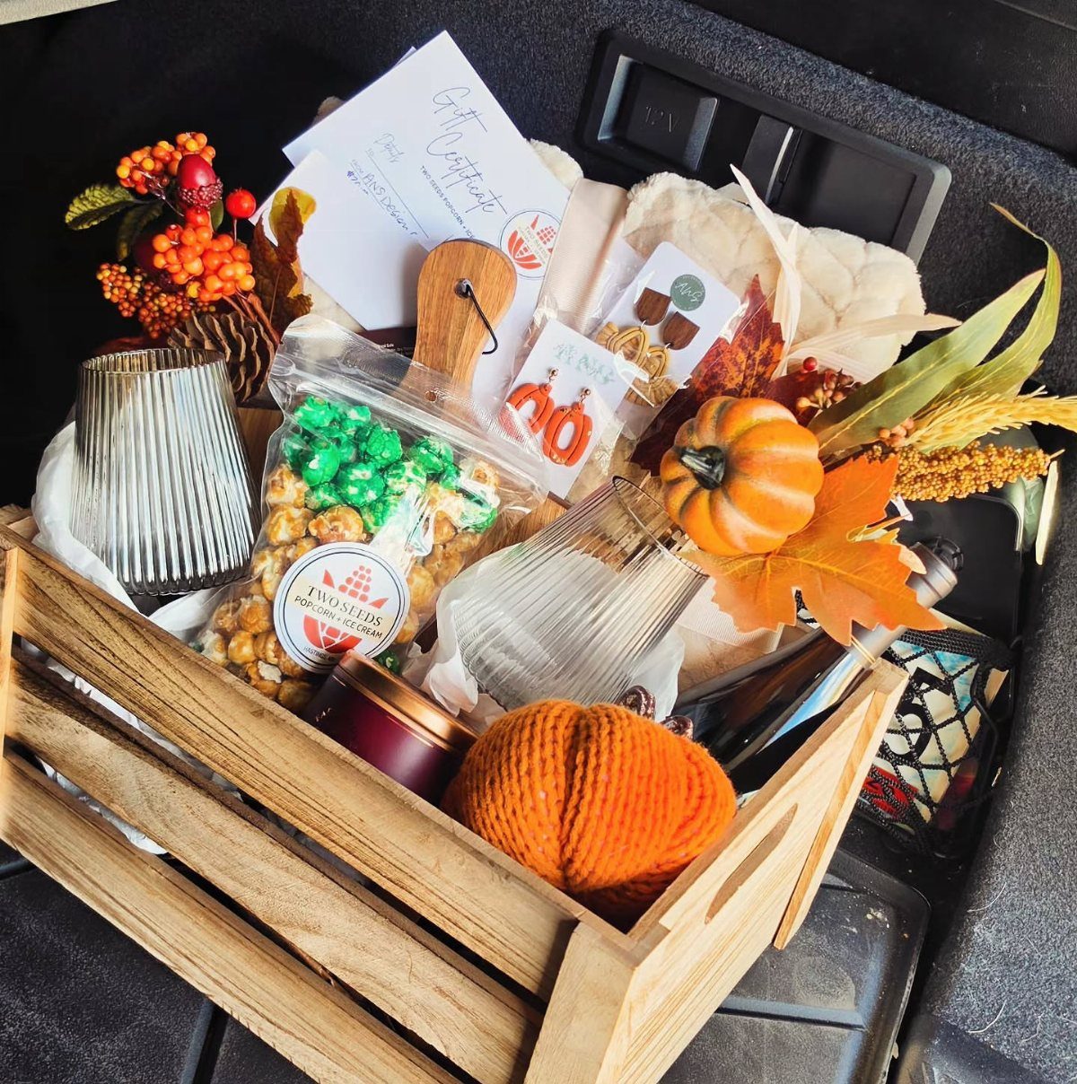 Wooden gift crate filled with gourmet popcorn, pumpkins, and autumn-themed treats.