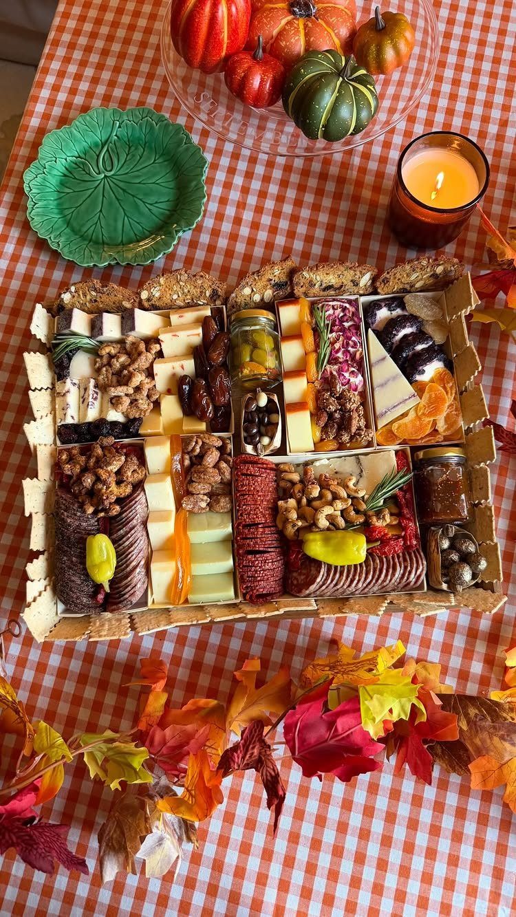 13 Fall Gifts for Women, From Cozy Socks to Cookbooks 3 Charcuterie board with meats and cheeses on a checkered cloth with autumn decorations