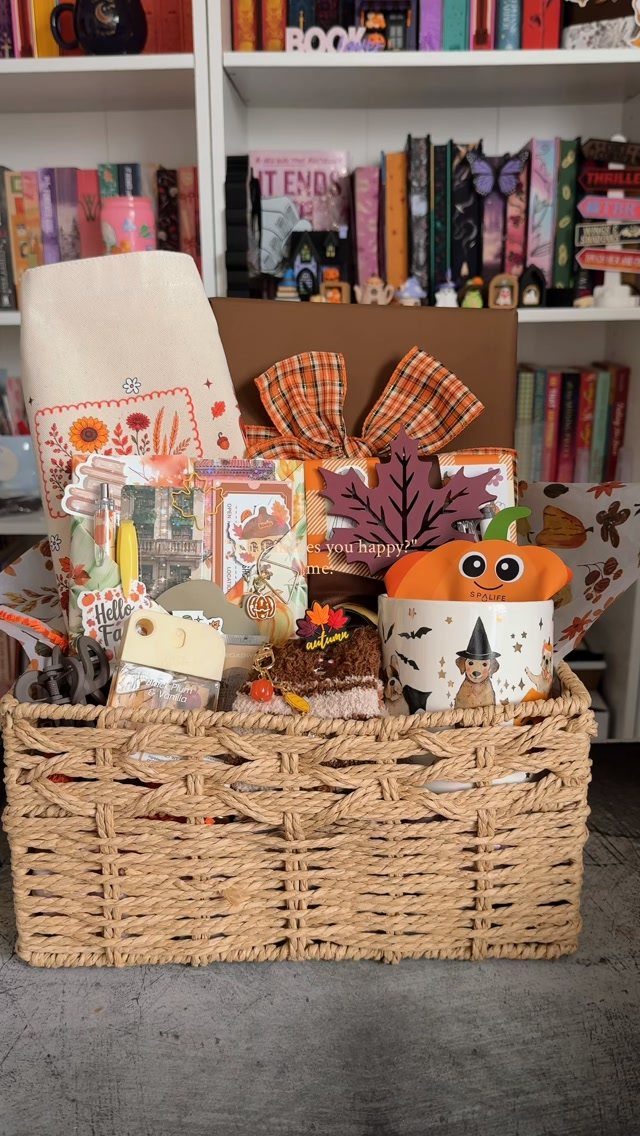 13 Fall Gifts for Women, From Cozy Socks to Cookbooks 6 Woven wicker basket filled with autumn-themed gifts, a mug, and stationery items.
