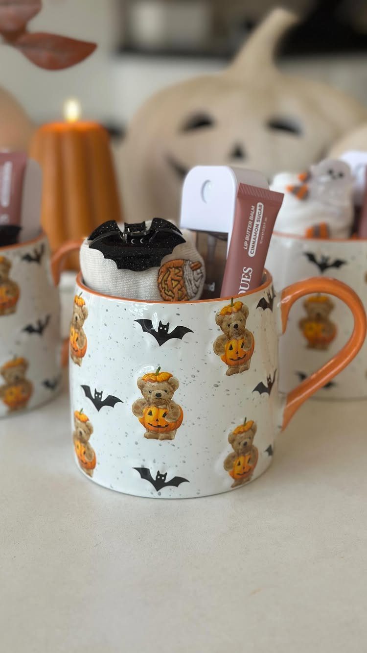 13 Fall Gifts for Women, From Cozy Socks to Cookbooks 7 White ceramic mug with autumn bears and bats filled with small gift items