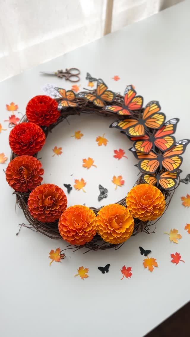 8 Fall Inspired Gifts for Cozy Autumn Gatherings 7 Autumn wreath made of grapevine, orange paper flowers, and yellow paper butterflies.