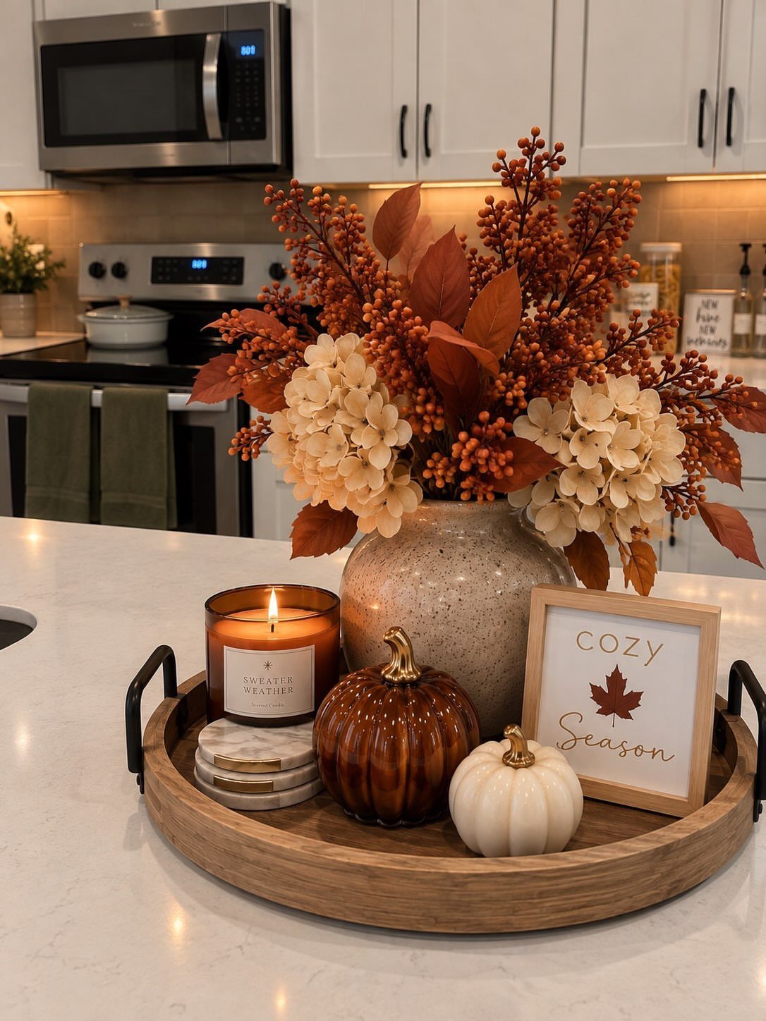 8 Fall Inspired Gifts for Cozy Autumn Gatherings 4 Two small ceramic pumpkins and a candle on a wooden autumn decor tray.