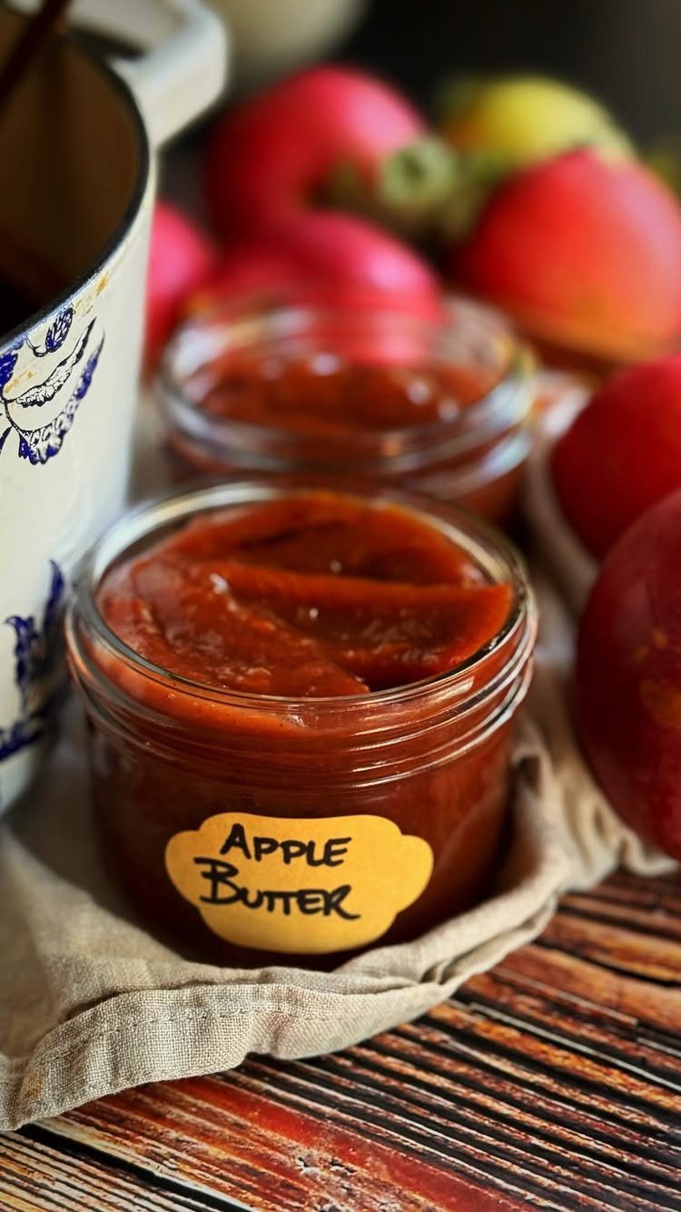 8 Fall Inspired Gifts for Cozy Autumn Gatherings 5 Glass jars of apple butter with a yellow label on a wooden table.