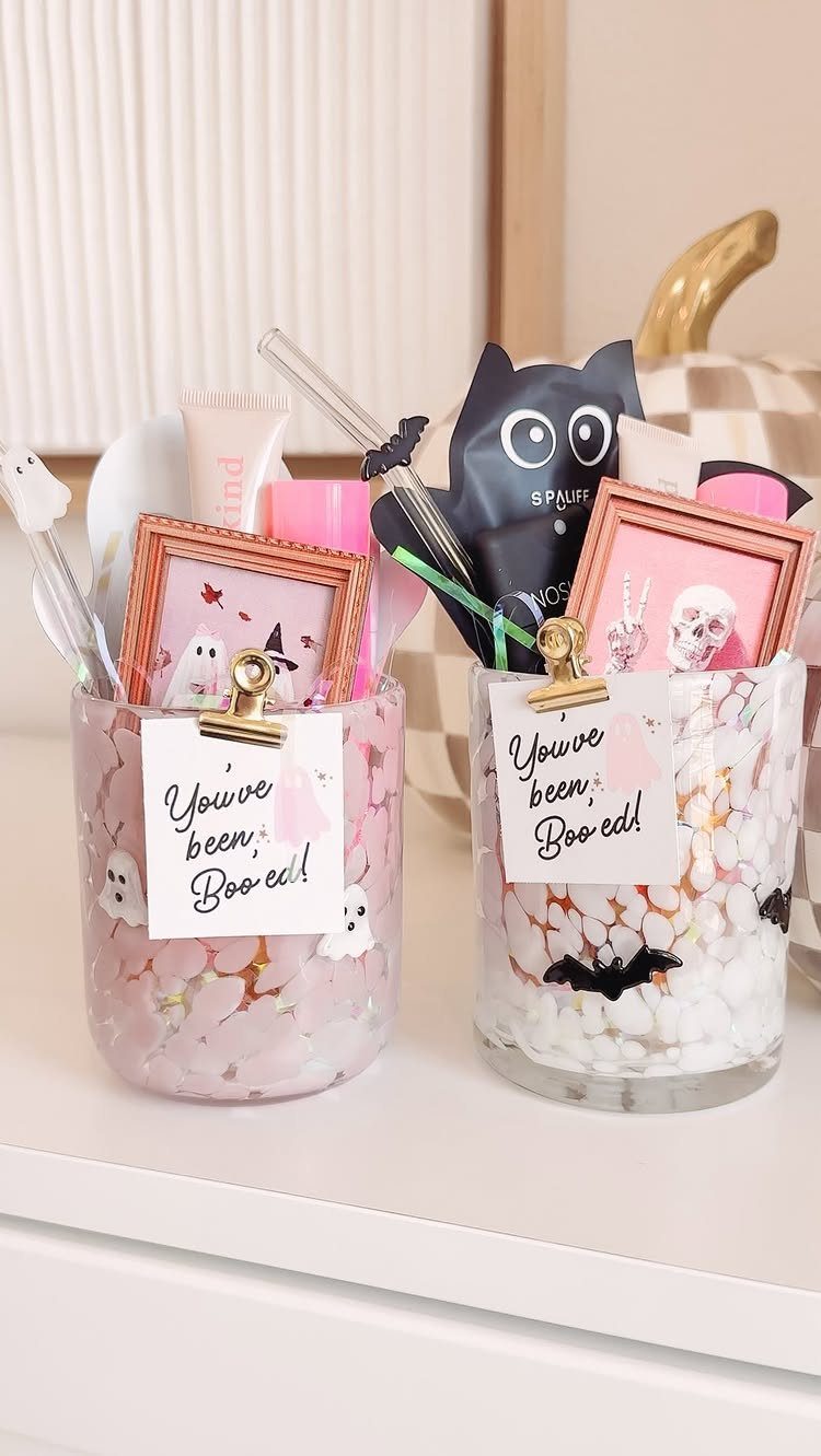 Two gift jars filled with stones, mini frames, and Booed notes for fall.