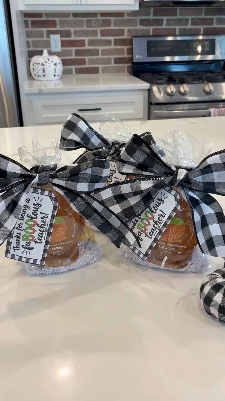 Honey jars wrapped in cellophane with checkered bows and teacher appreciation tags.