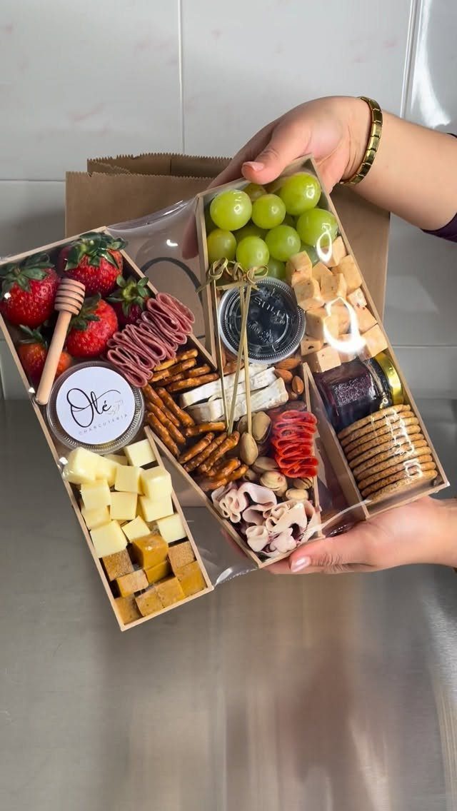 Wooden charcuterie gift box filled with assorted cheeses, meats, fruits, and crackers.