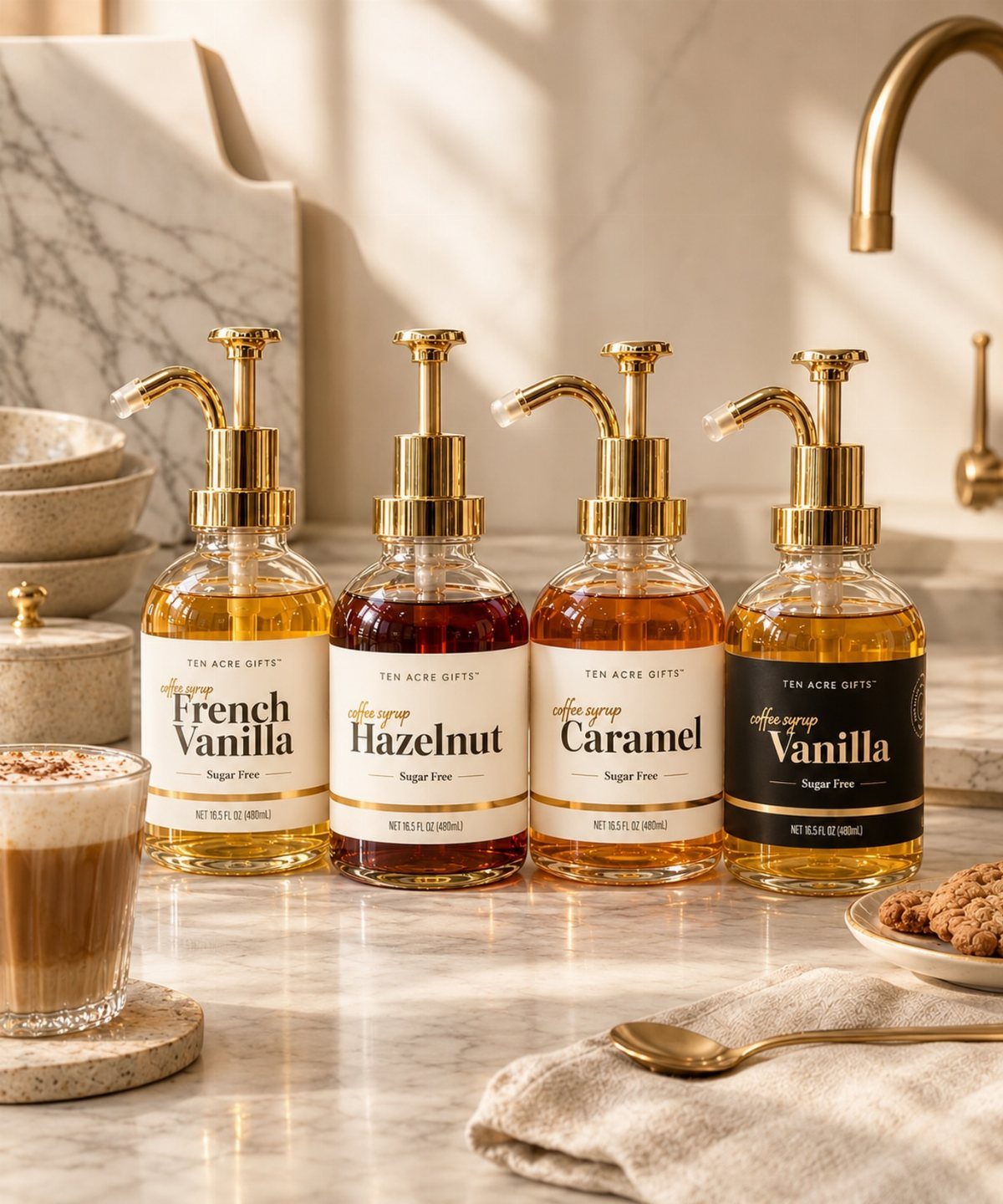 15 Friendsgiving Gift Ideas for Hosts and Guests 10 Four gold-pumped coffee syrup bottles on a marble counter with a latte.