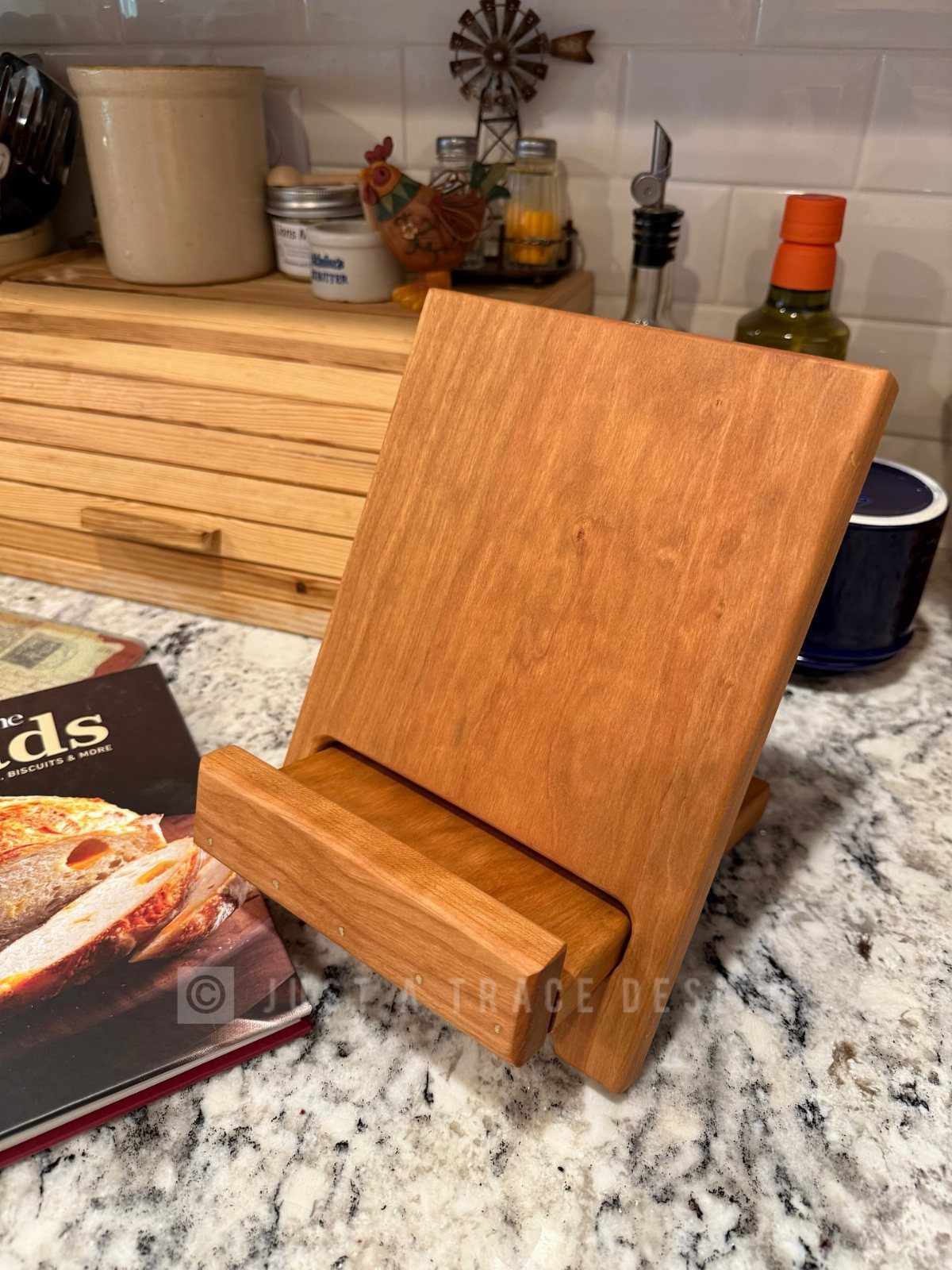 15 Friendsgiving Gift Ideas for Hosts and Guests 3 Wooden cookbook stand on a granite kitchen counter next to a cookbook.