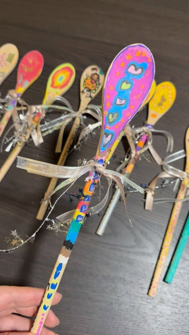 15 Friendsgiving Gift Ideas for Hosts and Guests 12 Painted wooden spoons with colorful patterns and silver ribbons as handmade gifts.