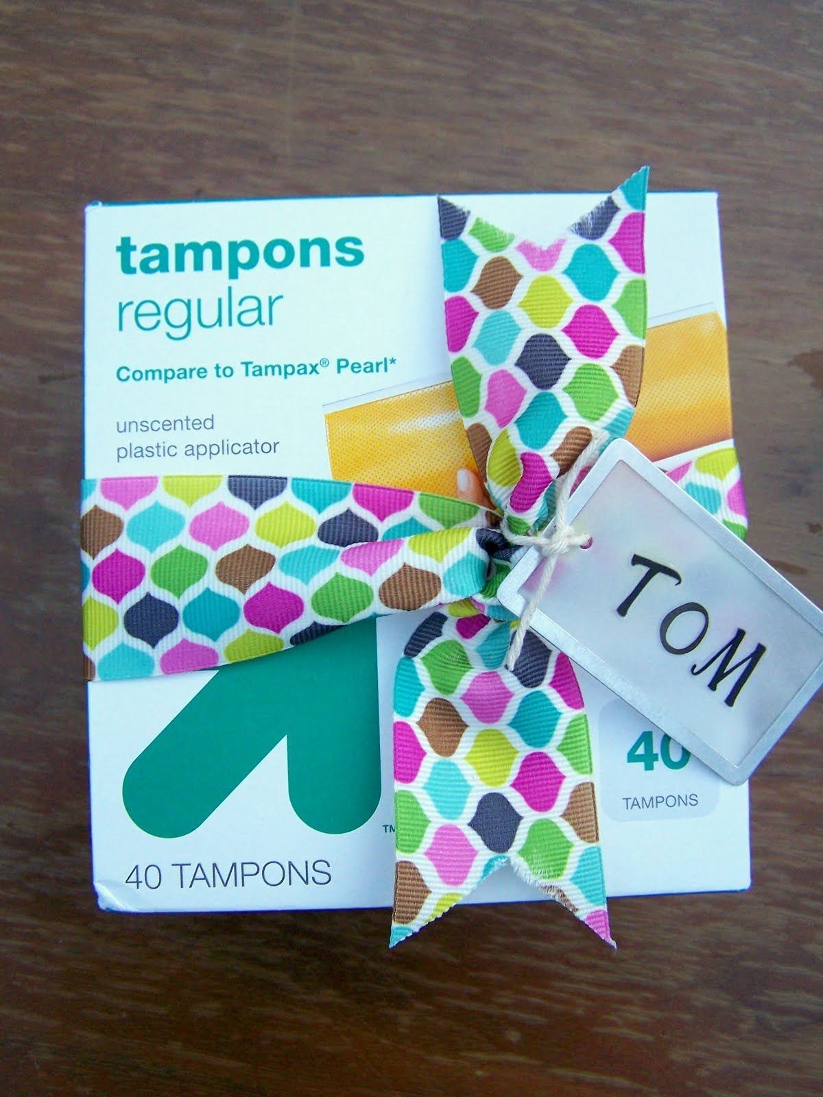 9 Funny Christmas Gift Wrapping Ideas Your Family Will Love 9 Box of tampons wrapped with a colorful ribbon and a tag for Tom.