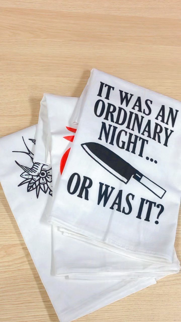 13 Funny Gag Gift Ideas for Birthdays and Office Parties 2 White kitchen towels with a humorous phrase and knife illustration on wood.